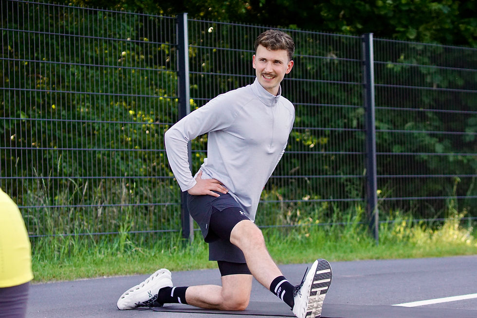 Gerrit Huber, Personal Trainer macht seinem Kunden eine Dehnungsübung beim Outdoortraining vor.