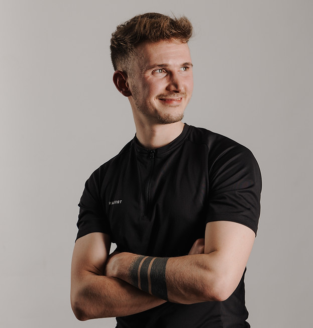 Portrait von Gerrit Huber, Personal Trainer, in sportlicher Kleidung, lächelt in die Kamera