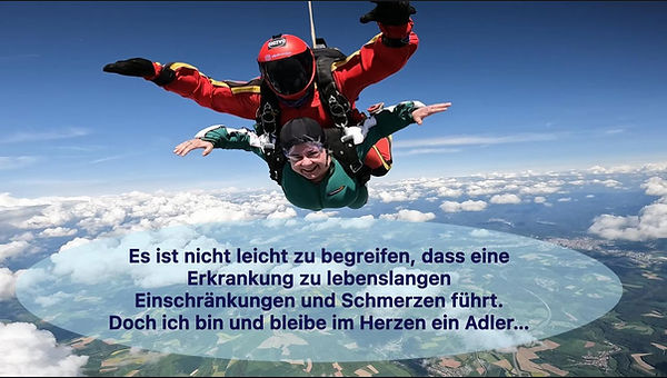 Foto von mir beim Tandem-Fallschirmsprung über den Wolken. Ich breite die Arme wie ein Adler aus, mein Tandem-Partner ist über mir sichtbar. Auf dem Bild steht: ‚Es ist nicht leicht zu begreifen, dass eine Erkrankung zu lebenslangen Einschränkungen und Schmerzen führt. Doch ich bin und bleibe im Herzen ein Adler.