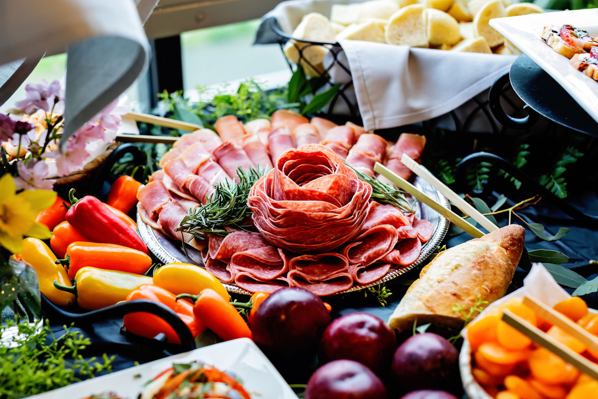 Buffet spread with deli meats, fresh vegetables, and fruits