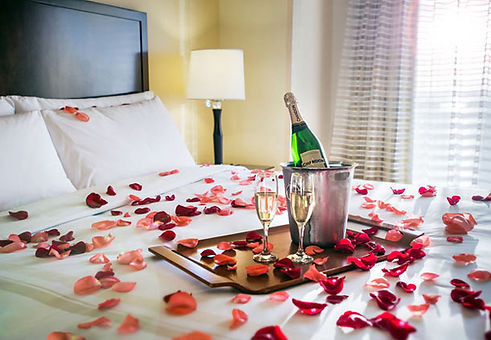 Champagne and roses on the bed