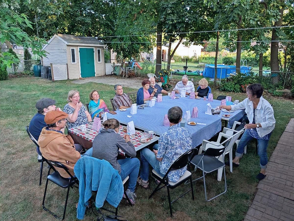 A diverse group of people eating around a big table at Meals & Stories