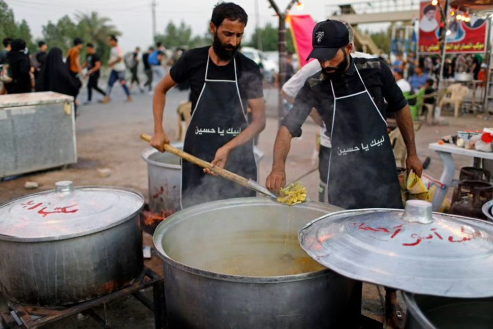 志工在煮大鍋飯。 Picture by REUTERS/Thaier Al-Sudani