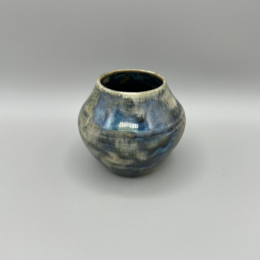 Handcrafted ceramic vase with a smoke-toned glaze and organic shape.