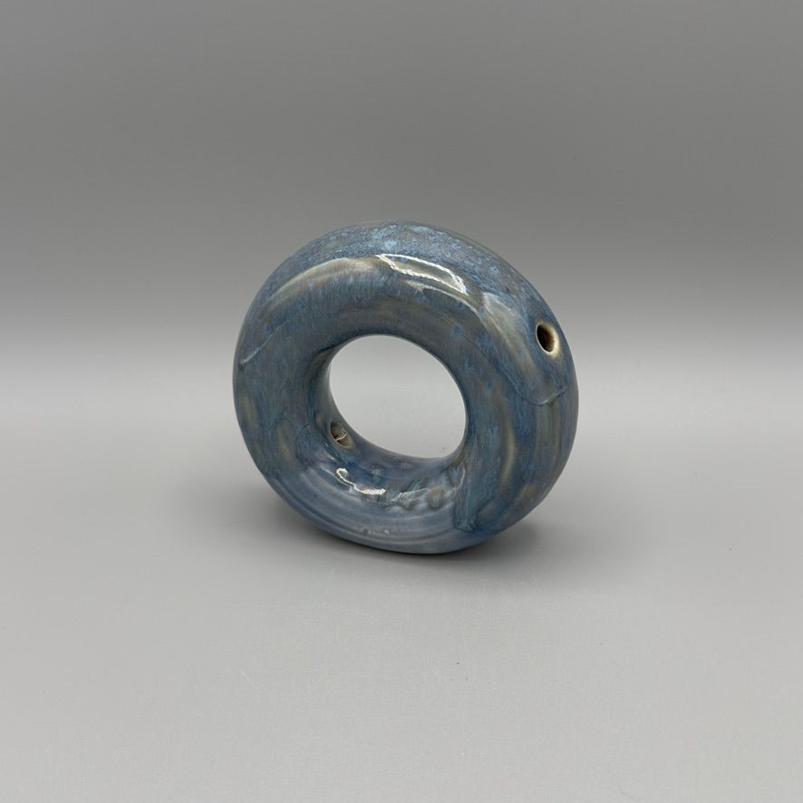 Handcrafted circular donut vase in blue opal glaze with oyster tones, modern ceramic decor piece.