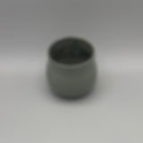 Handmade smoke-glazed ceramic vase with a soft, curved form and neutral tones.