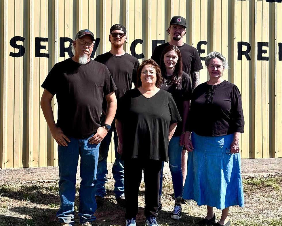 The full team at S&S Auto and Diesel standing in front of the yellow shop building in Mineral Wells, TX—multi-generational, family-owned auto repair crew.
