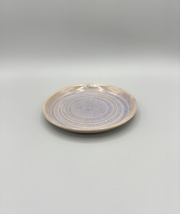 Handcrafted gray opal ceramic tea cup and saucer set with floral handle detail.