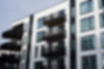 New residential complex featuring sleek balconies and large windows set against the skylin