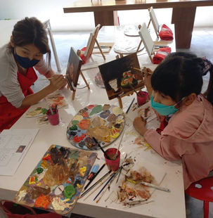 mother and child paint together on canvas art class