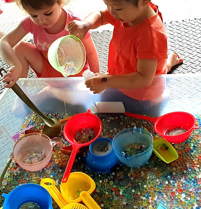 sensory play with colour pearls in daycare class early years development milestones personal social and emotional developments