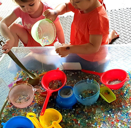sensory play with colour pearls in daycare class early years development milestones personal social and emotional developments