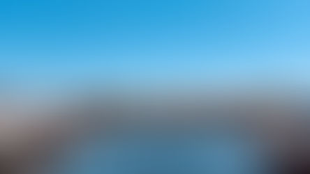 A view of a marina with boats and blue sky and water