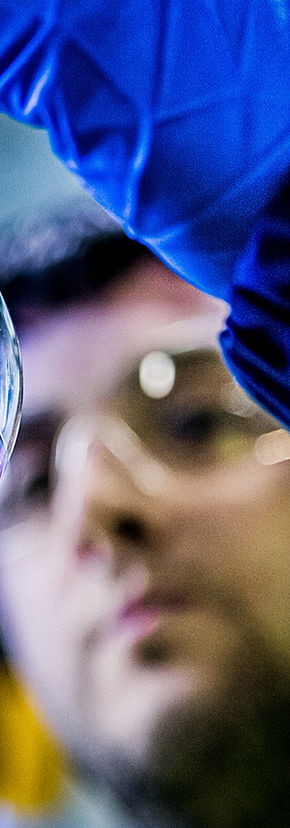 Photographer takes close up of chemical in glass vessel