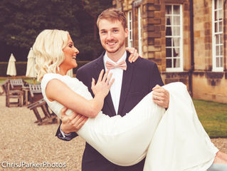 Wedding Groom carries is bride outside Crathorne Hall Hotel