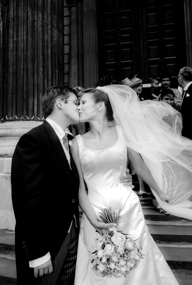 Wedding photographer captures wedding couple kissing