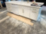 White kitchen island with light tile flooring installation