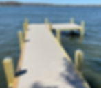 L-shaped composite boat dock with solar lights on a lake