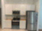 Modern kitchen with white shaker cabinets and stainless steel appliances