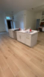Modern kitchen with white island and light tile flooring.