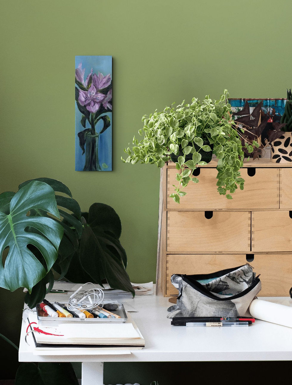 Thumbnail: Beth Hempton's purple alstroemeria oil painting hanging on a green wall above a desk