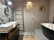 Salle de bain moderne avec double vasque, baignoire noir, miroir rond. Atelier LG architecture.