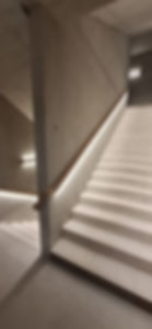 Escalier carrelé, avec voile béton brut, main courante et appliques e, bois naturels, avec éclairage LED intégré