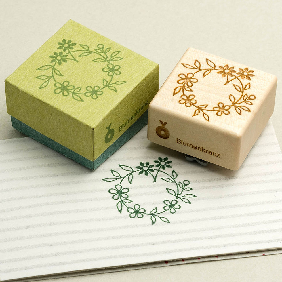 Motivstempel aus Holz & lasergraviertem Gummi mit der Illustration eines zarten, filigranen Blumenkranzes mit Schachtel.