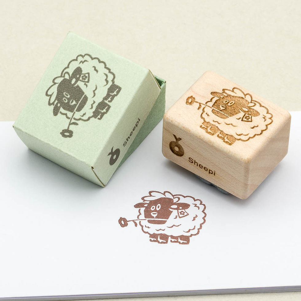 Schaf-Stempel mit Holzgriff und passender grüner Schachtel; unten der Schafabdruck in braun auf weißem Papier.