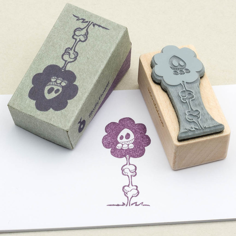 Blumen-Stempel mit Knochen-Totenkopf-Motiv gestempelt auf weißem Papier; ein violetter Abdruck, Ansicht Stempelseite.