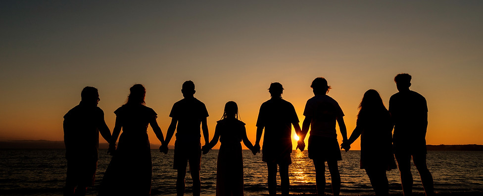 Family photo against a sunset on a beach