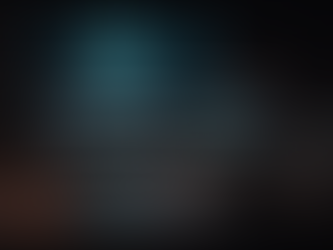 Sound engineer workspace with mixing console, headphones, and multiple screens displaying audio waveforms and film footage in a dark studio environment.