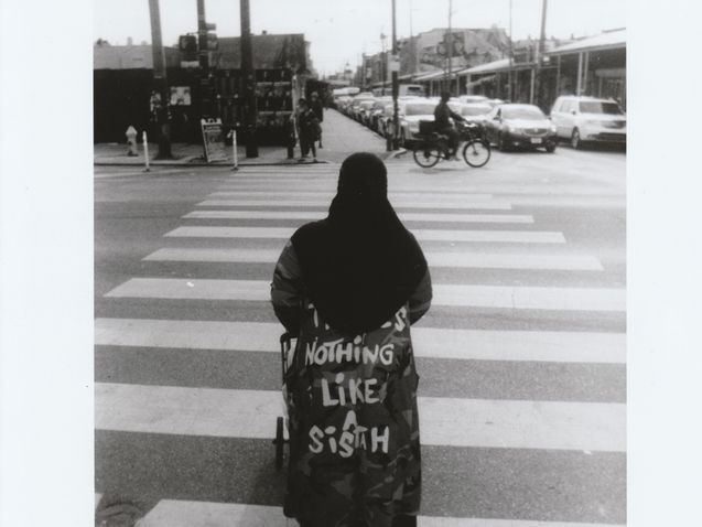 Woman in wheelchair with jacket that says "Nothing Like a Sistah"