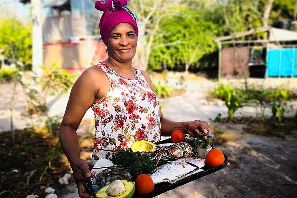 Mujer sostiene peces y frutas tíícas de la región de la costa Caribe colombiana