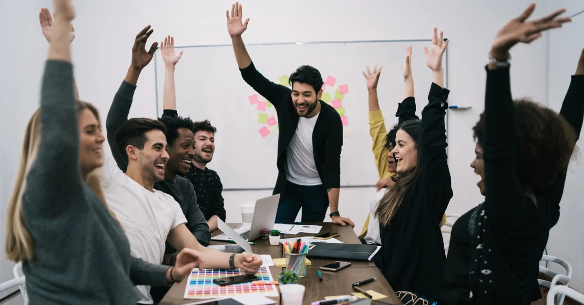 people  in an office raising their hands 