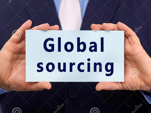 Hands holding a sign reading "Global sourcing" in bold blue text. The person is wearing a dark suit with a light blue shirt and white tie.