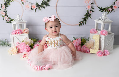 Baby girl in pink tutu surrounded by pink flowers