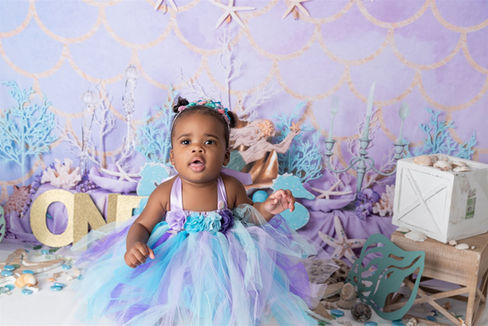 Little girl dressed as a mermaid for her cake smash photoshoot