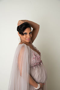 Pregnant woman poses in mauve and pink gown