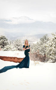 snowy winter maternity photo in dark green gown