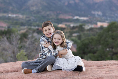 brother and sister hug outside garden of the gods