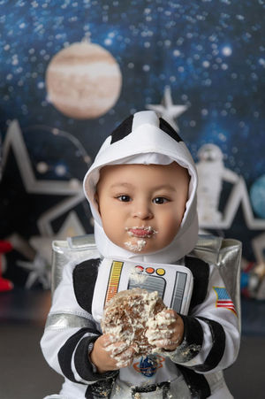 Photo of a little boy dressed as an astronaut eating cake