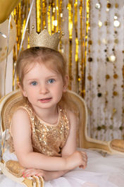 Little girl dressed in gold with a gold crown