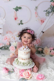 Smiling baby girl surrounded by pink flowers