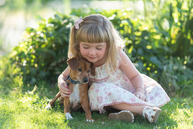 Outdoor photo of a little girl and her puppy