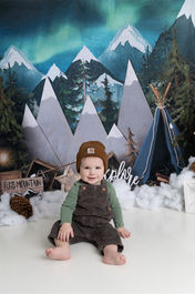 Photo of a little boy in front of a camping backdrop
