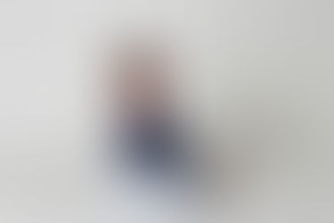 Little girl dressed in white and blue against a white backdrop