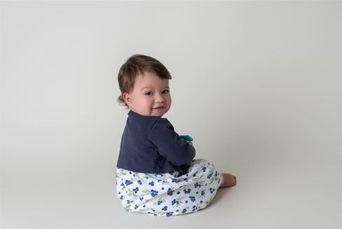 Little girl dressed in white and blue against a white backdrop