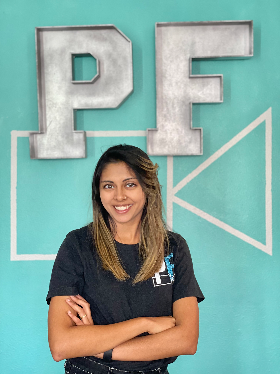 Woman smiling in front of a PF logo wall