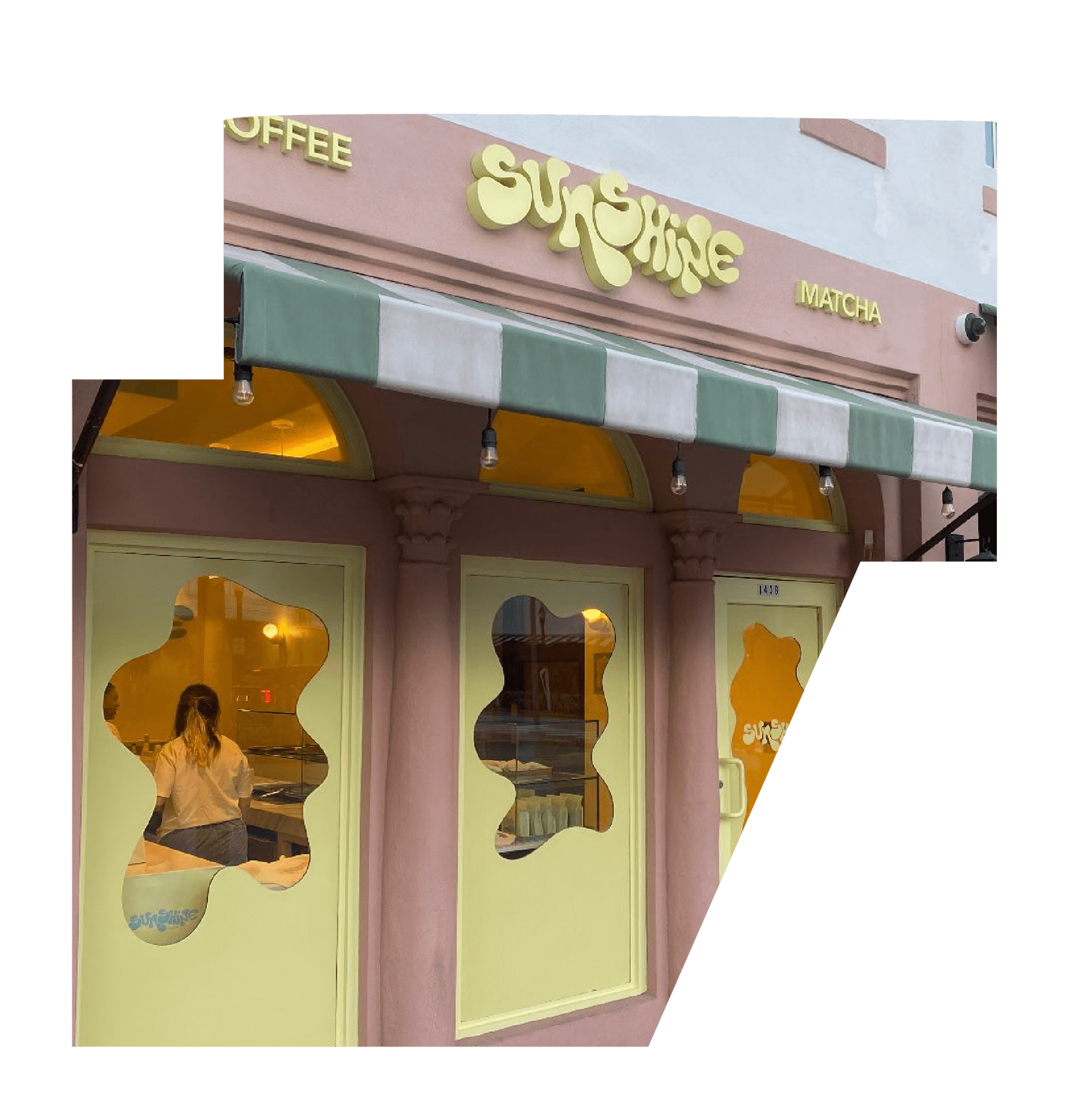 Exterior of Sunshine Café and Matcha Bar featuring pastel yellow and pink design, green-and-white awning, and a warm, welcoming atmosphere.